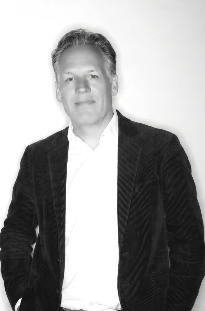 Black and white photo of a person wearing a dark jacket over a light shirt.